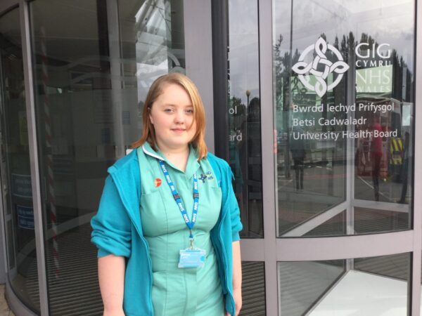 Young woman with Down syndrome wearing NHS uniform